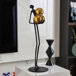 Miniature Human Holding Gold Ball Sculpture